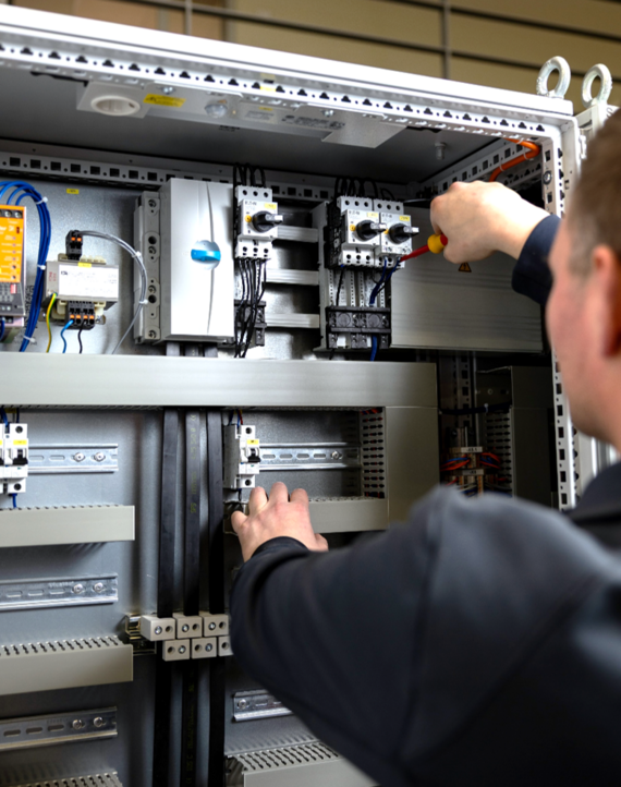 Bosch-Mitarbeiter schraubt eine Klemme in einem DIGICONTROL-Schaltschrank fest