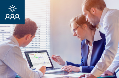 Zwei Herren und eine Dame schauen auf ein Notebook mit einem WEBPROJECT-Screen